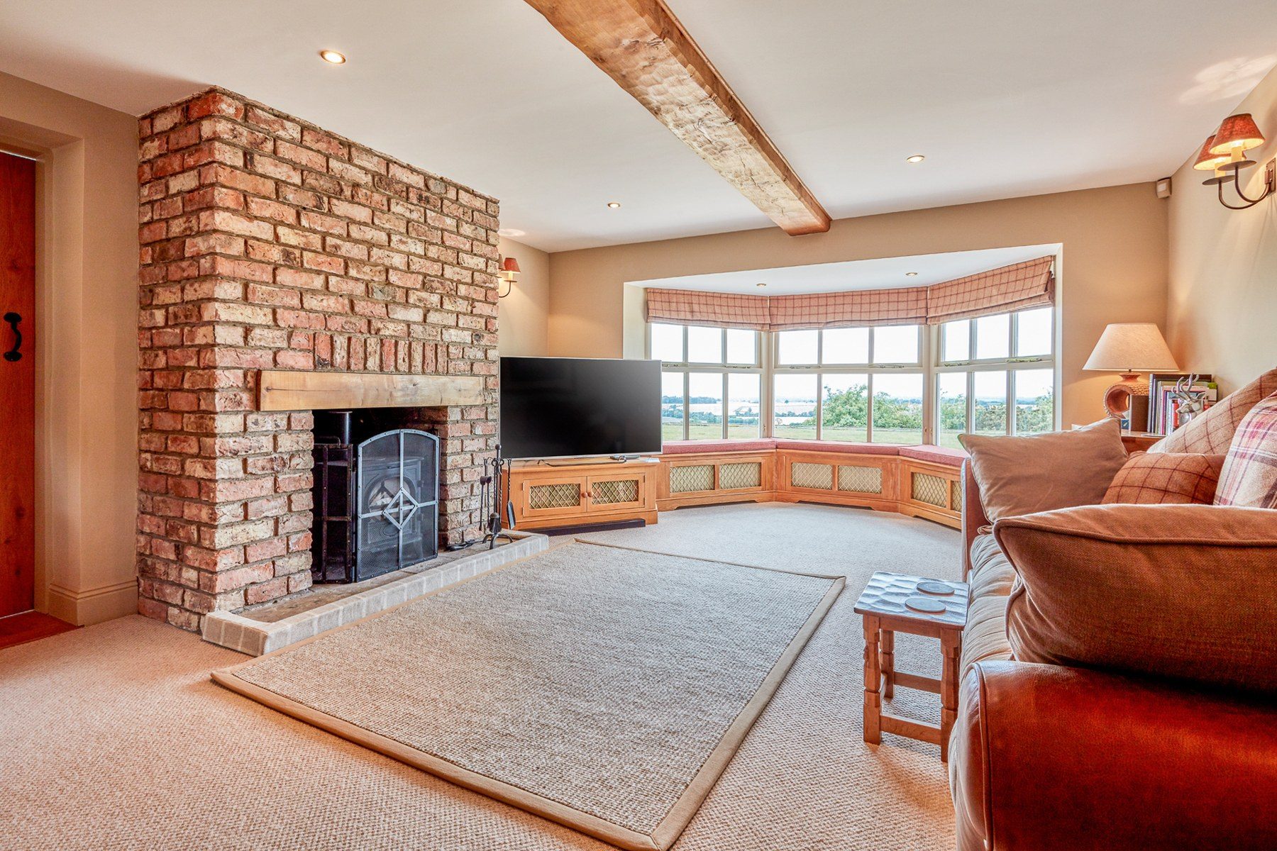 Second sitting room with brick fireplace and log burner