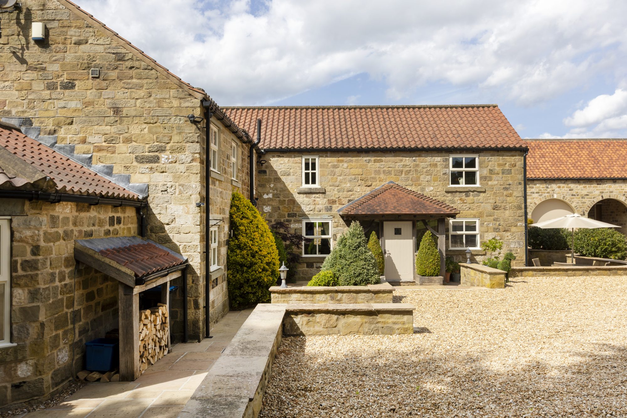 Stone outbuildings around the gravel courtyard