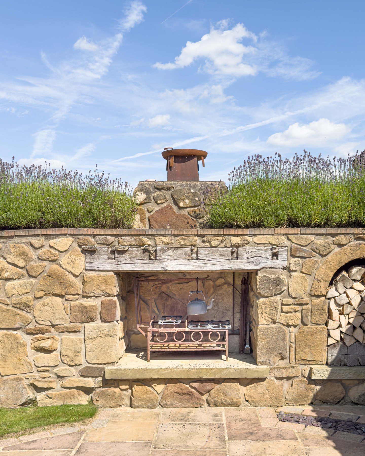 Stone outdoor kitchen and barbecue built into the garden wall