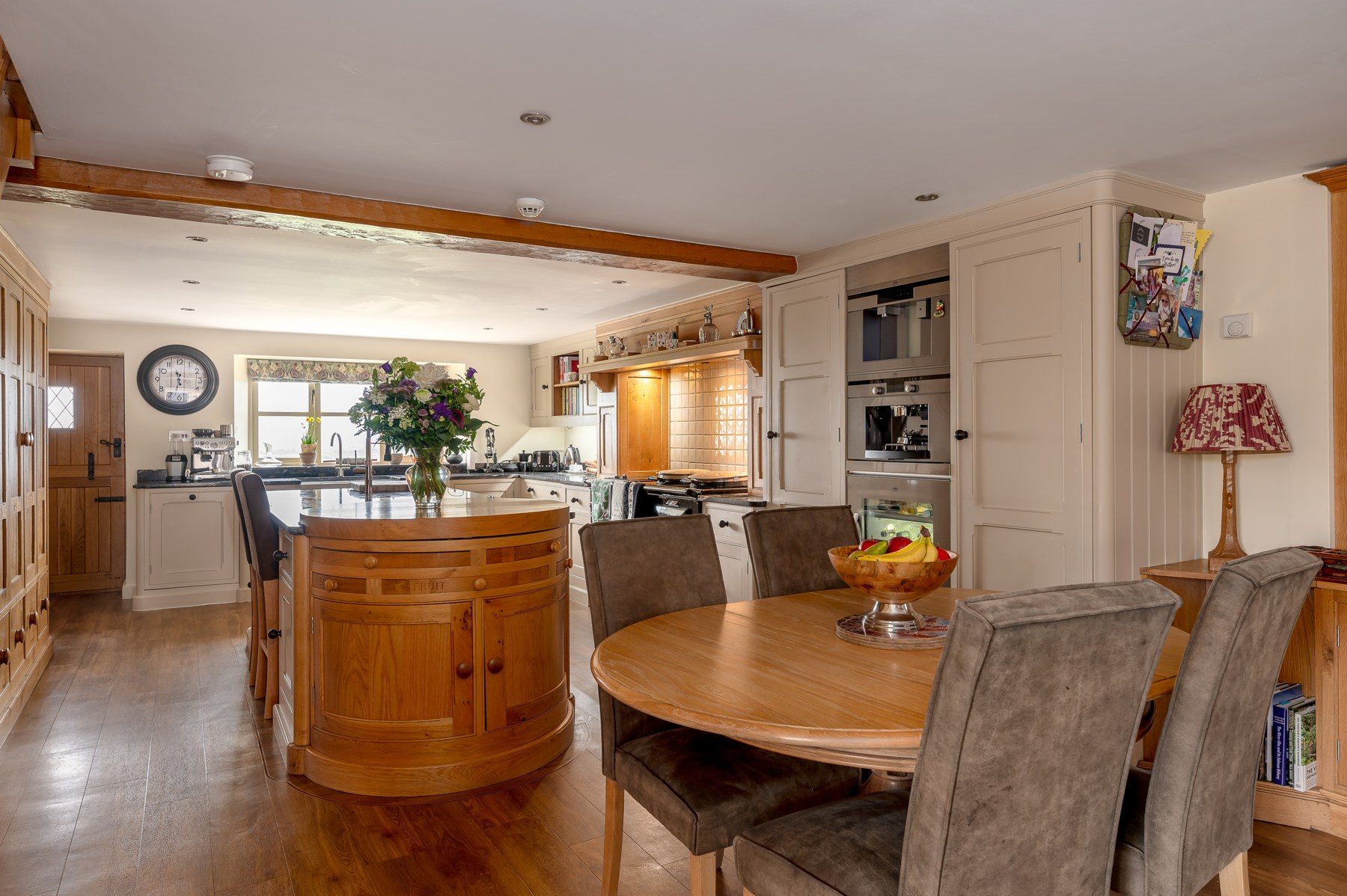 Oak kitchen island with dining table and bay window