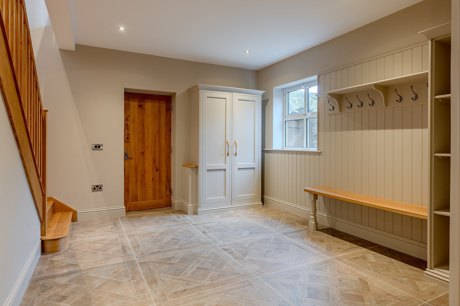 Boot room with hooks, bench and stone flooring