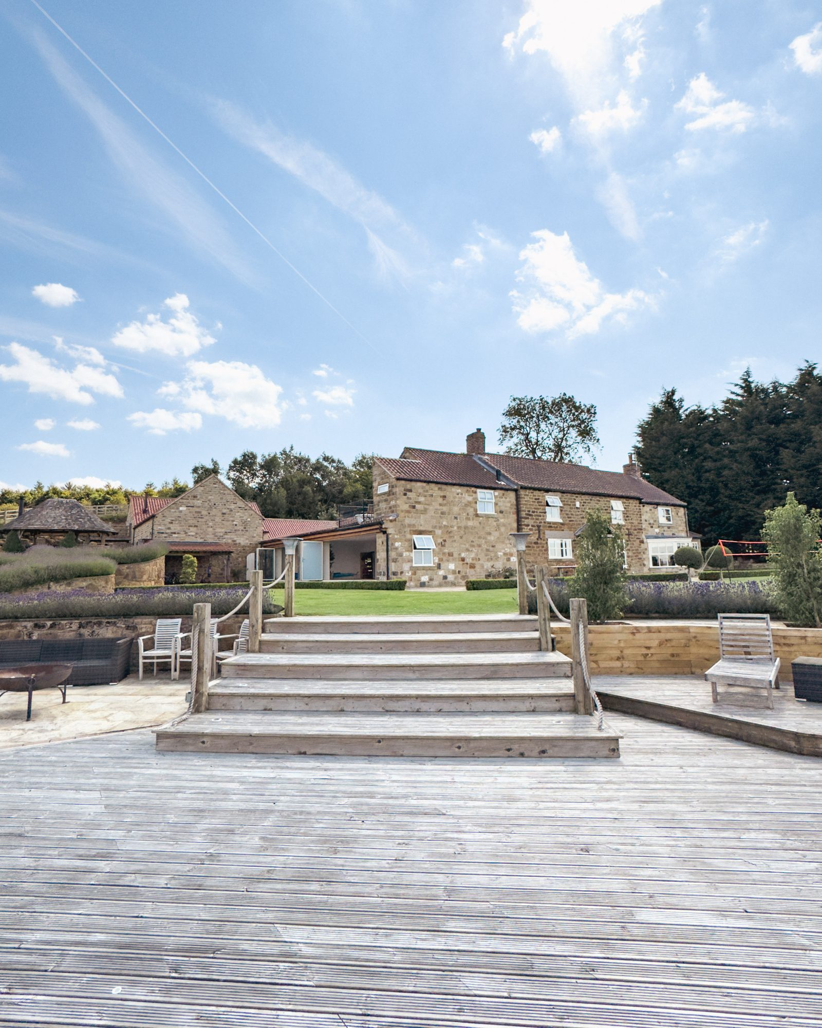 Wide timber steps up the deck towards the hot tub