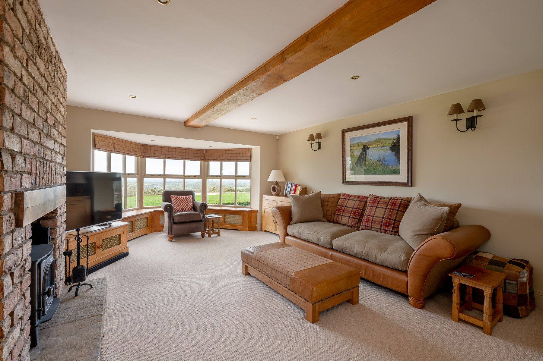 Sitting room with stone fireplace, wood burner and bay window