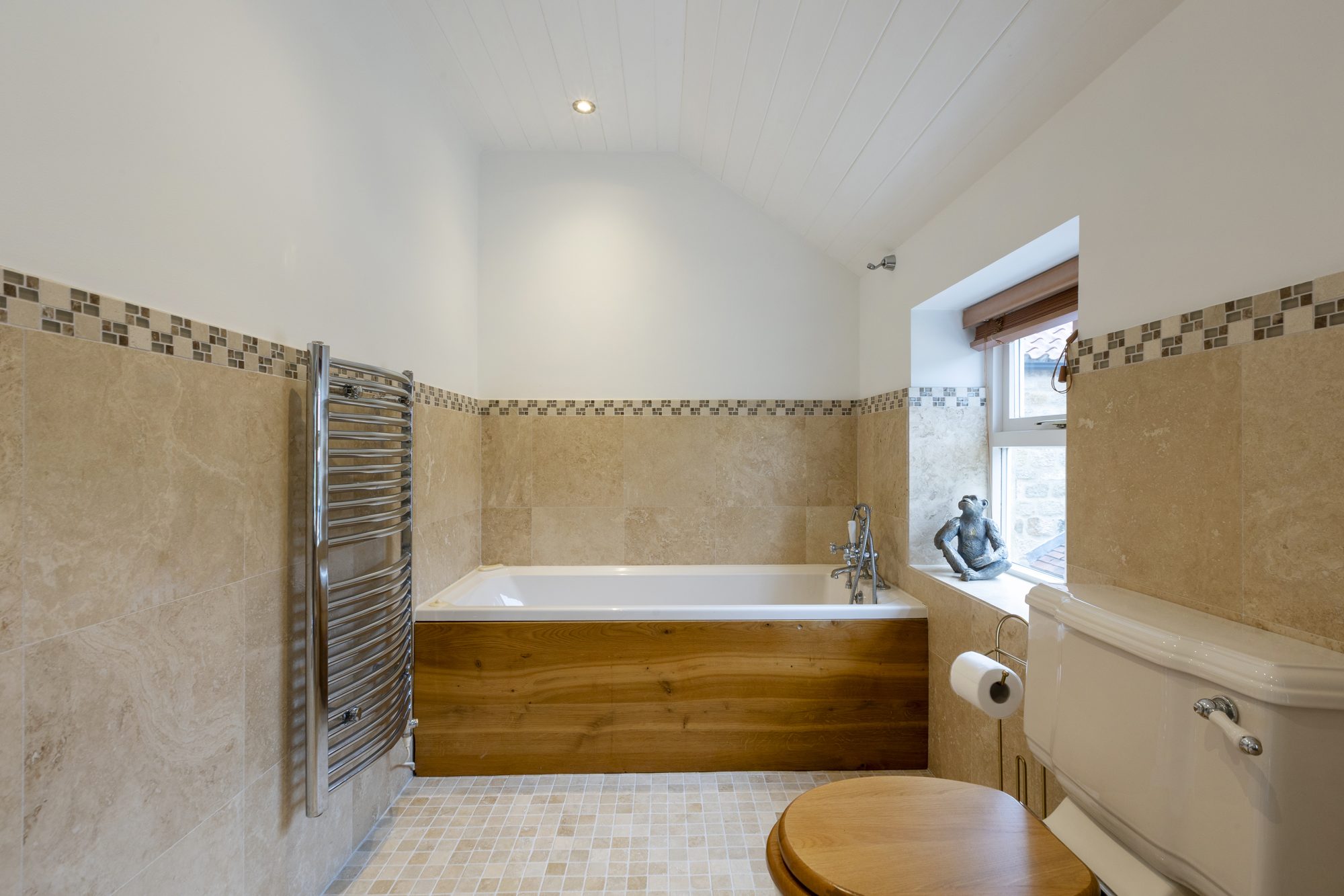 Bathroom with wood-panelled bath and mosaic tiles