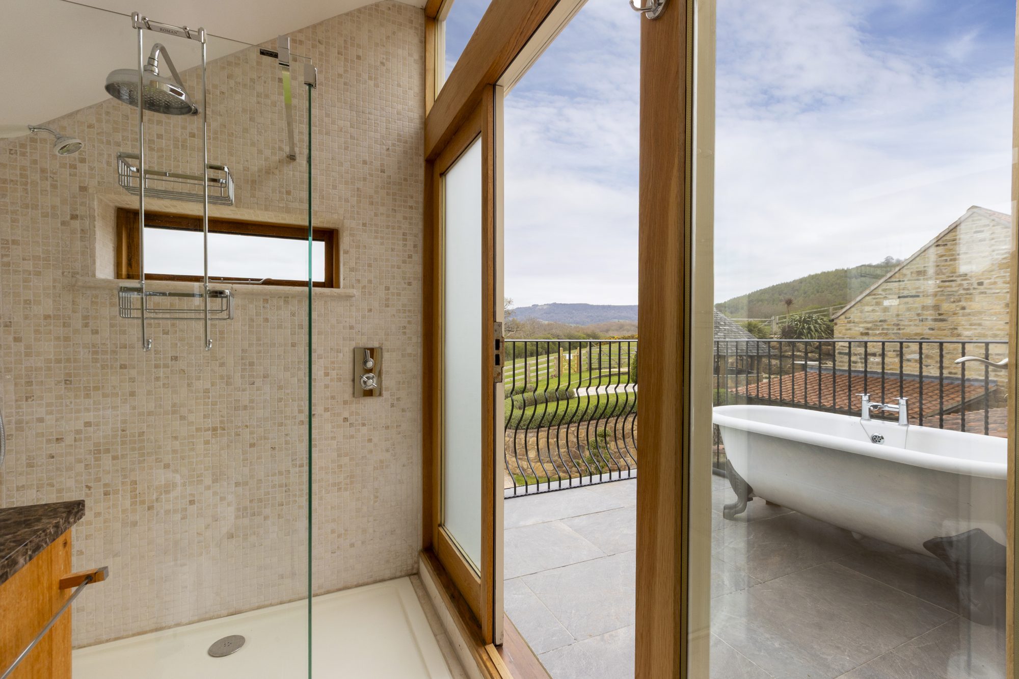 Indoor shower opening onto the balcony bath