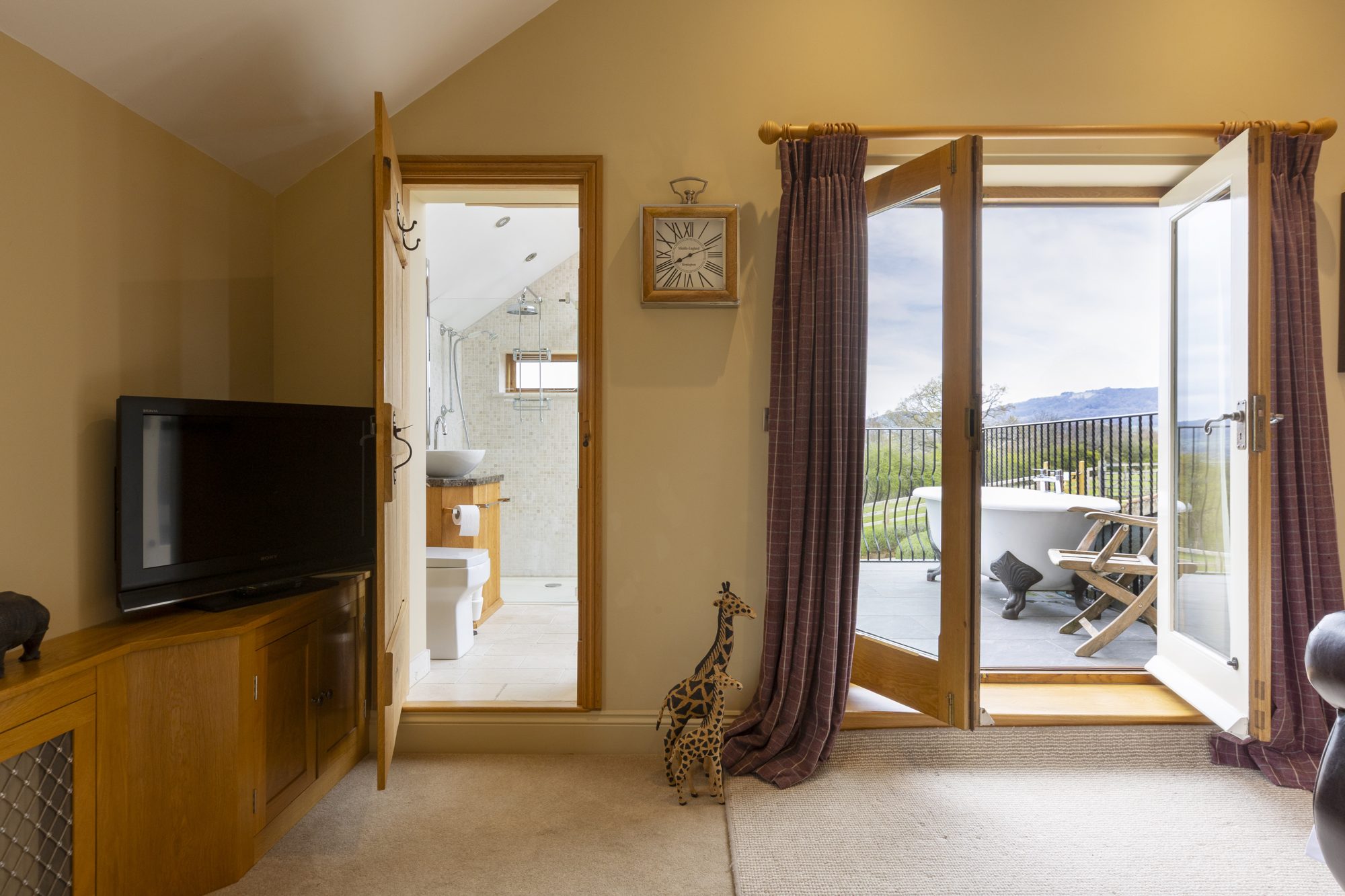 Bedroom 2 with television and doors onto the private balcony