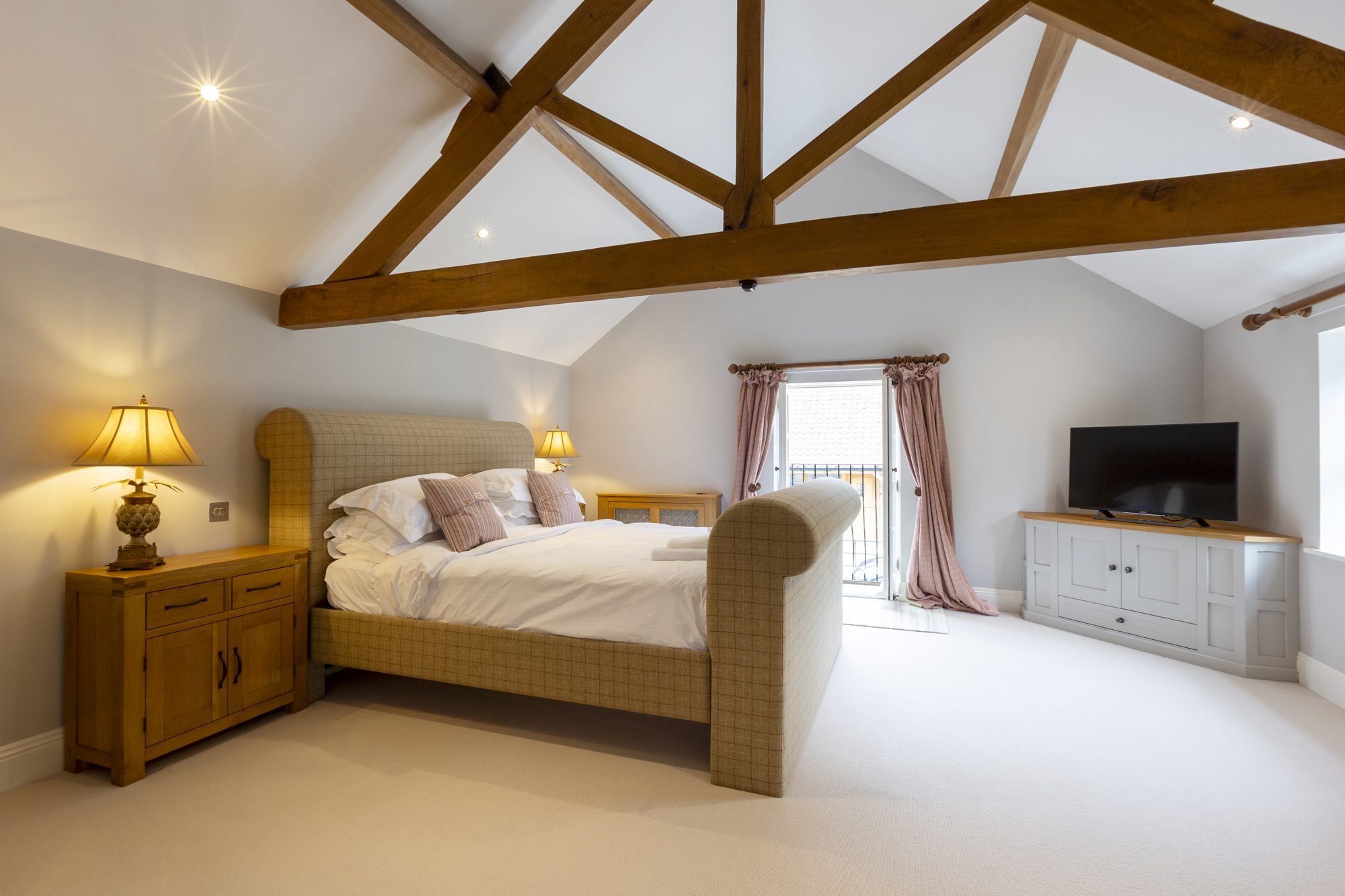 Bedroom 4 with exposed oak trusses and vaulted ceiling