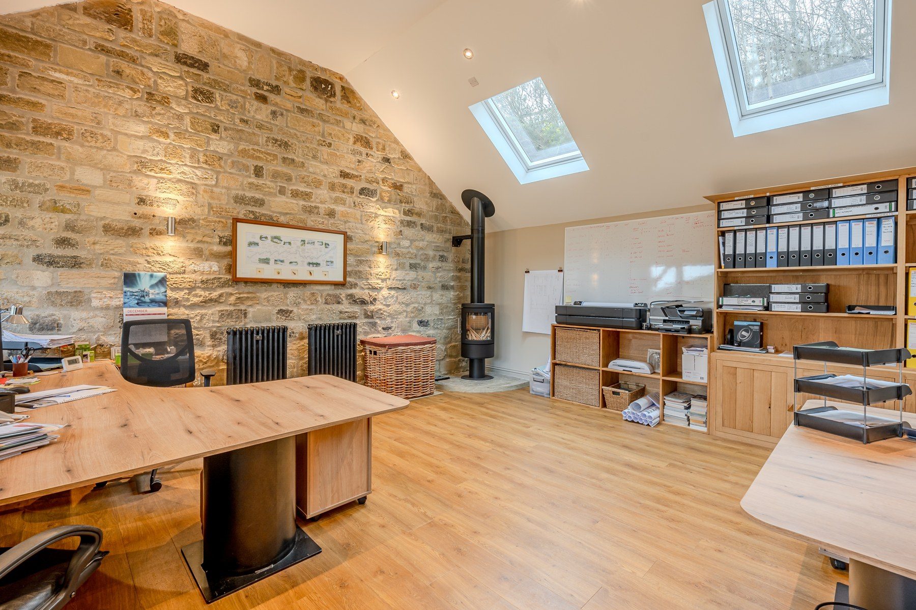 Study with exposed stone wall, wood burner and large desk