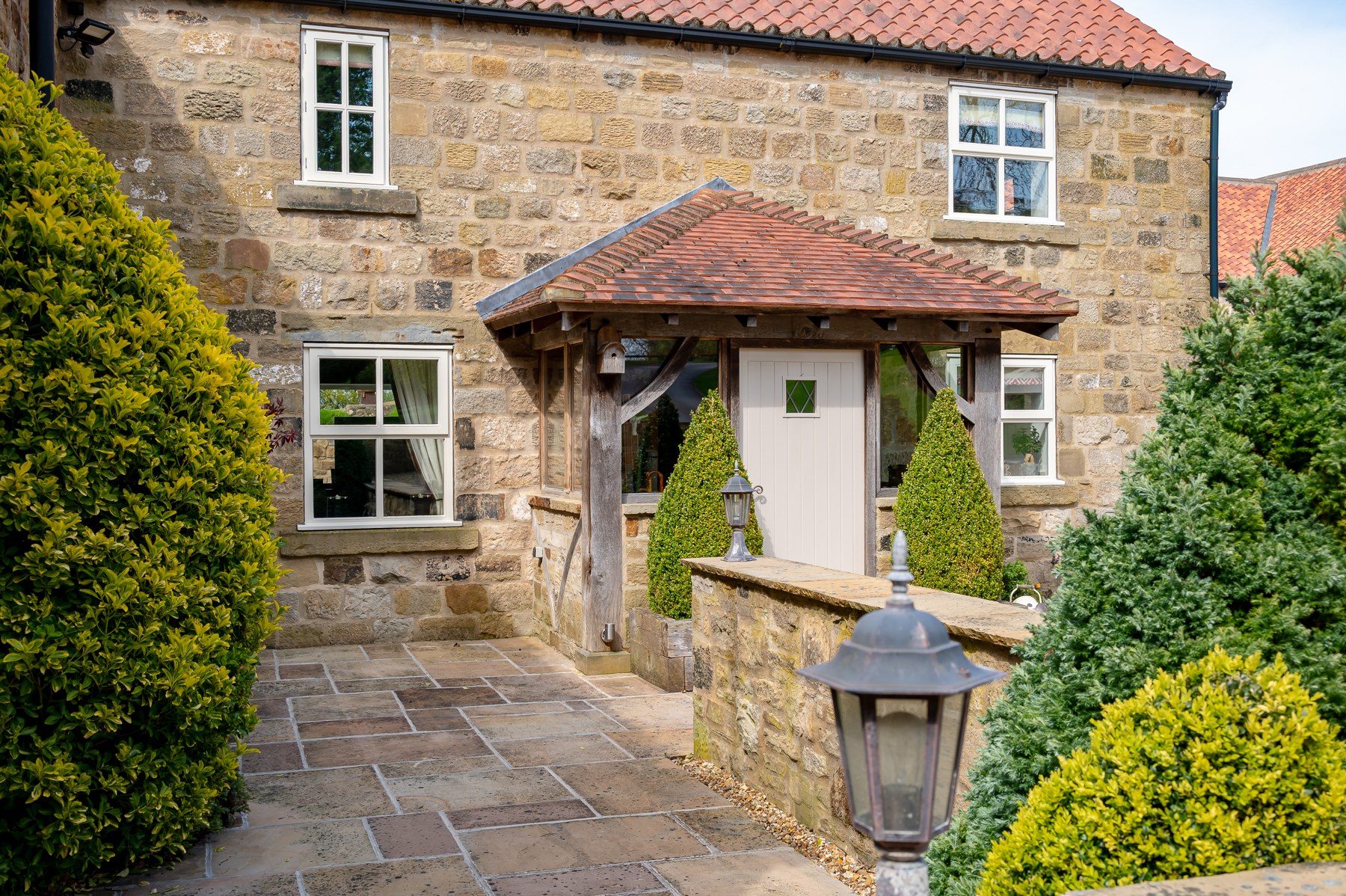 Stone entrance porch with clipped topiary