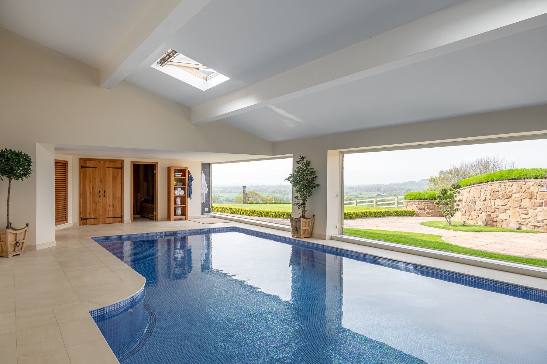 Pool room with bi-fold doors open to the countryside